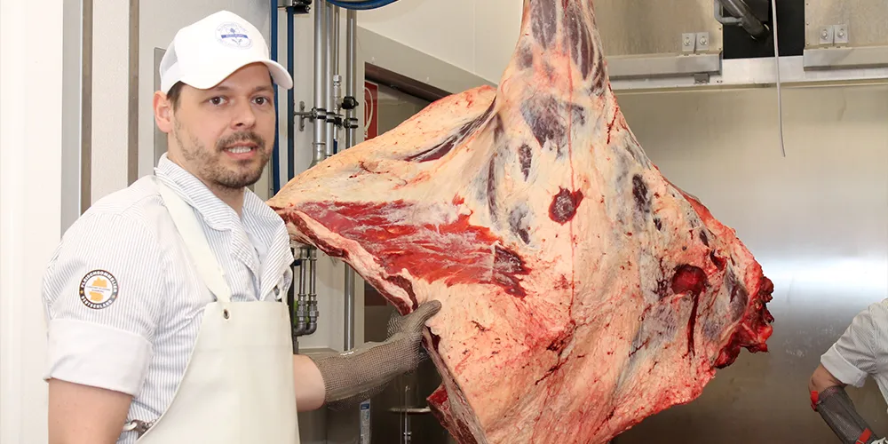 Metzger hält großes Rinderstück in der Hand